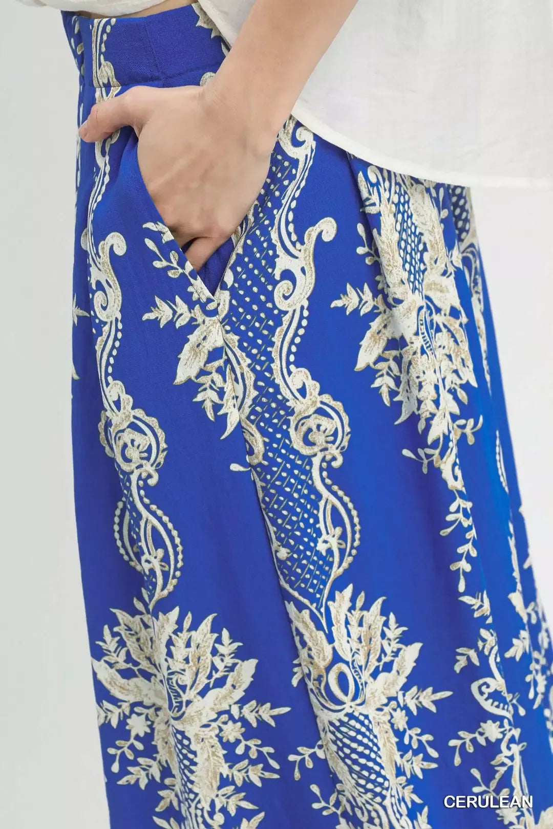 Flowy blue wide-leg pants with gold embroidered floral borders, elegant satin texture, high-waisted fit