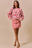 Pink vintage wash denim mini skirt with scalloped hem and front button closure
