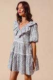 Grey and white floral cotton dress with ruffled V-neckline and tiered skirt featuring side tie detail