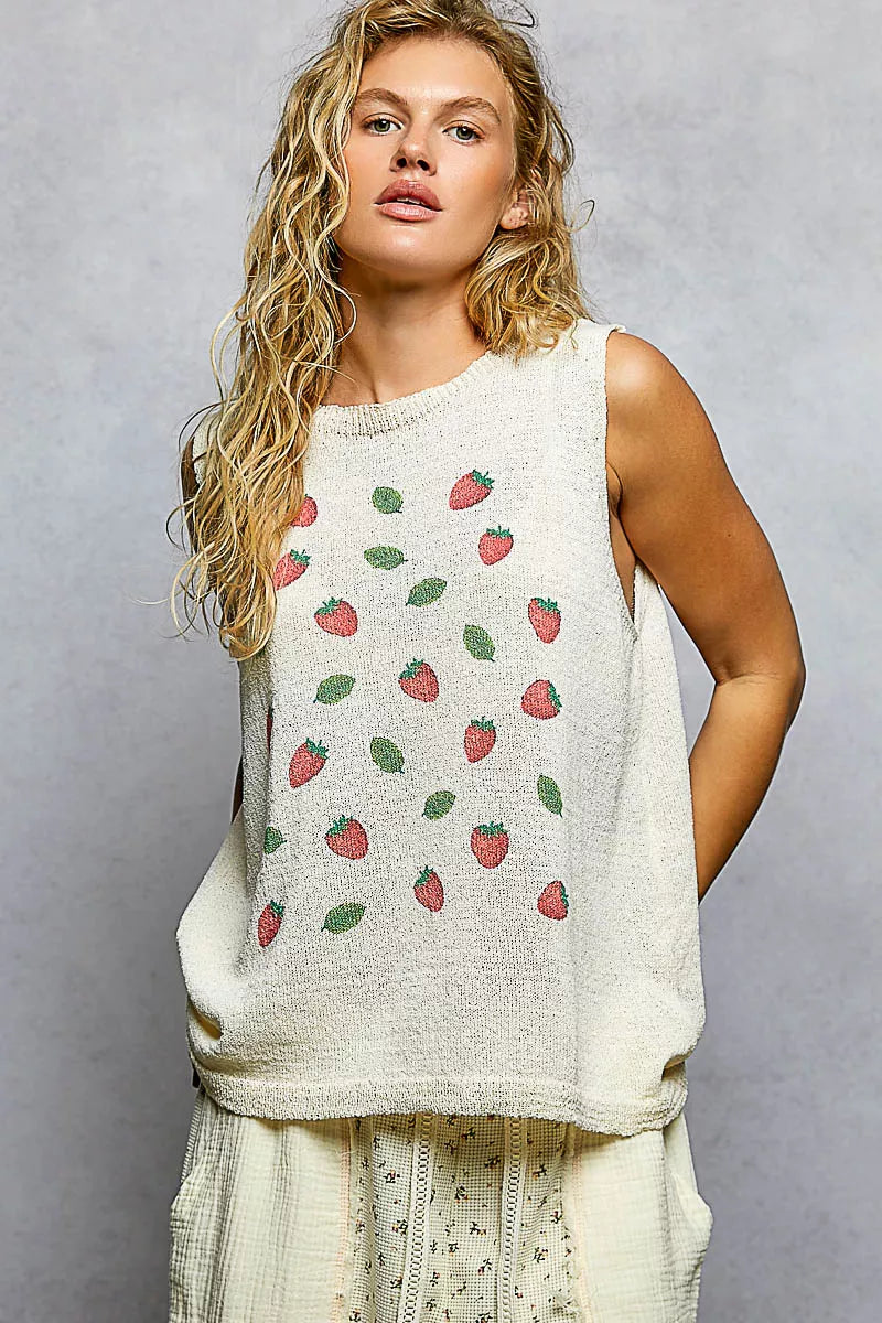 Cream knitted sleeveless top with red strawberry and green leaf pattern on loose fit fabric