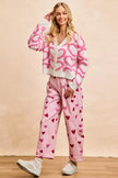 Pink textured heart patterned V-neck cardigan with button closure and cropped fit.