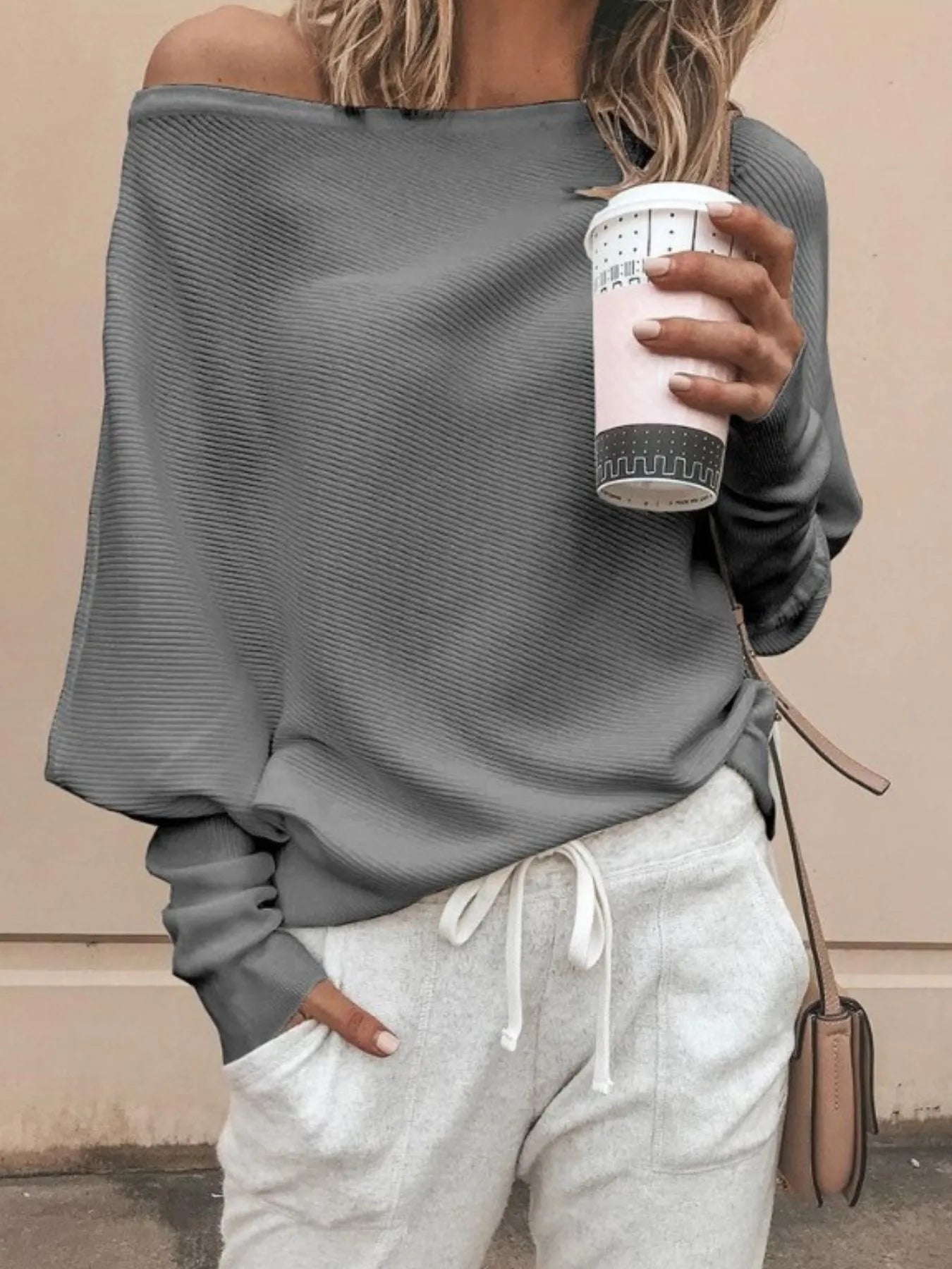 Relaxed fit ribbed knit top draped over arm showing breathable fabric