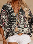 Black and white patterned V-neck top with pink accents, loose fit, textured polyester blend.