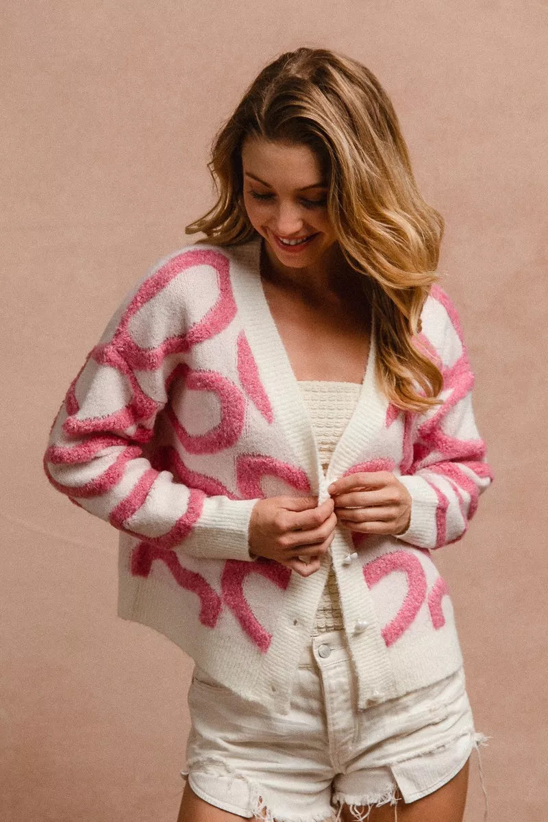 Pink and white textured heart patterned v neck cardigan with button closure