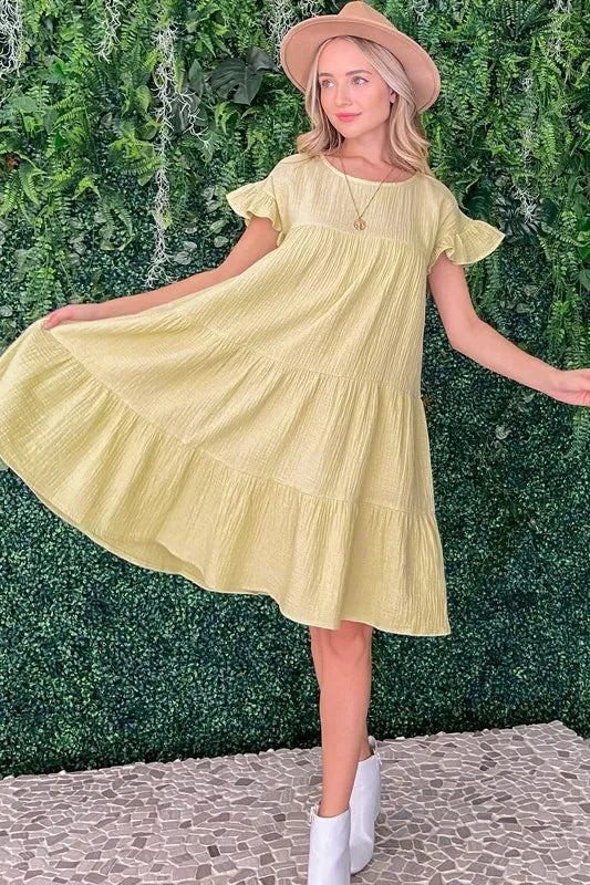 Light yellow cotton gauze babydoll dress with ruffled tiered skirt and short flutter sleeves
