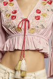 Pink cropped blouse with red and gold floral embroidery, beaded details, and tassel tie front.