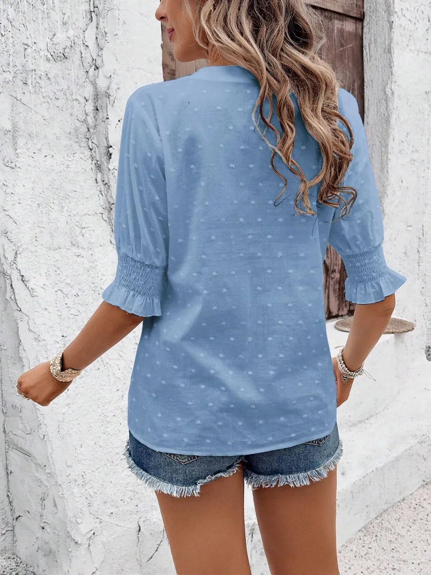 close-up of flounce sleeve ruffle and eyelet textured fabric on white blouse