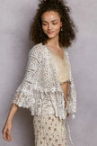 Openwork lace cardigan draped over neutral top