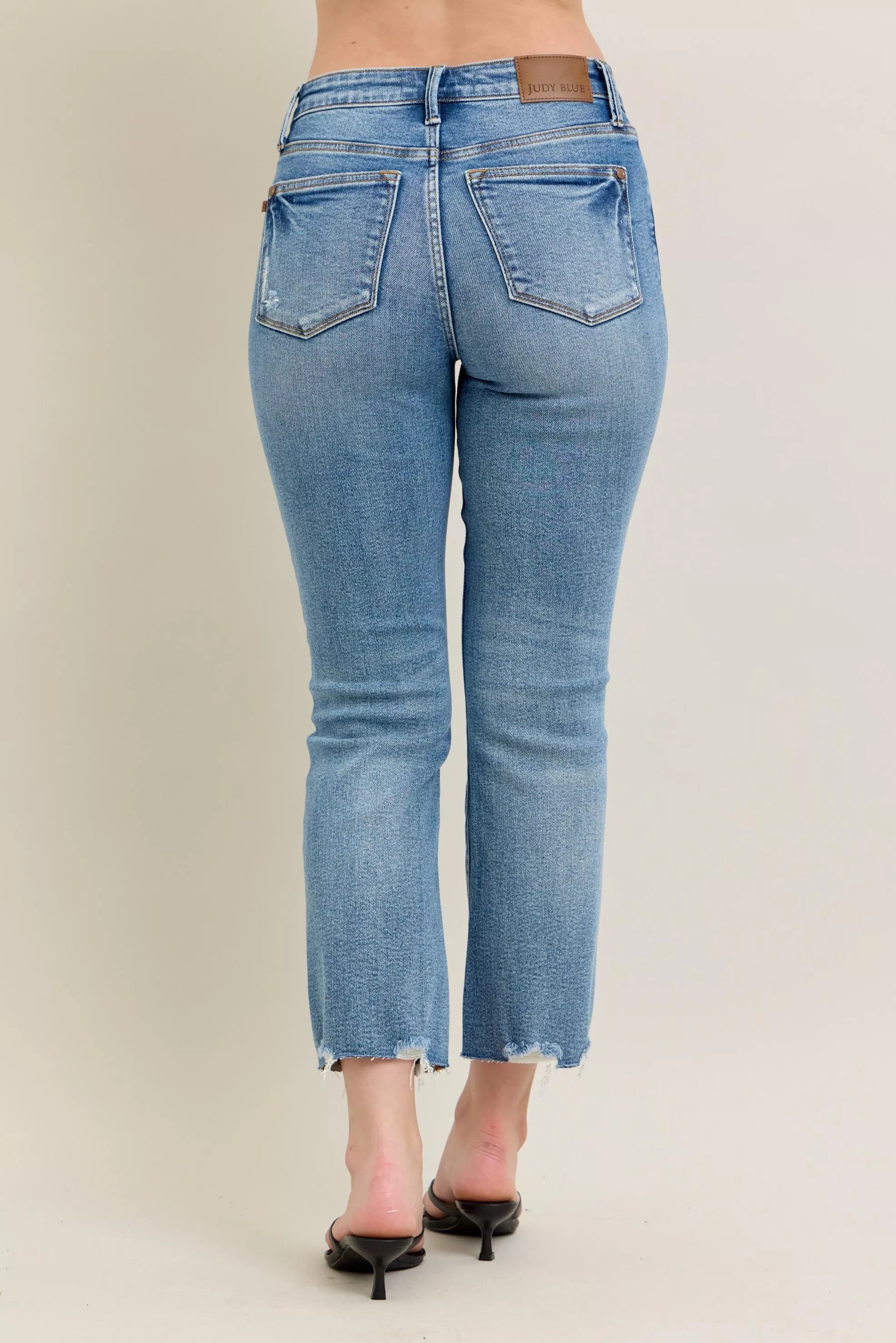 Light blue denim jeans with distressed hem and vintage wash texture, slim fit with kick flare.