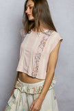 Pink cropped t-shirt with floral print, lace trim, and ribbed texture, fitted round neck design.