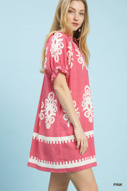 A-line pink linen mini dress with white floral print, ruffle sleeves, and scalloped border hem.