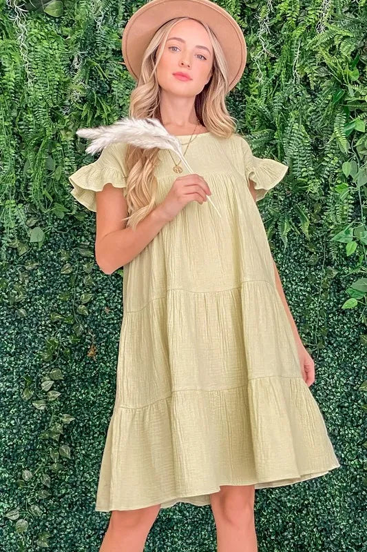 Light green cotton gauze baby doll dress with ruffled tiered skirt and short flutter sleeves