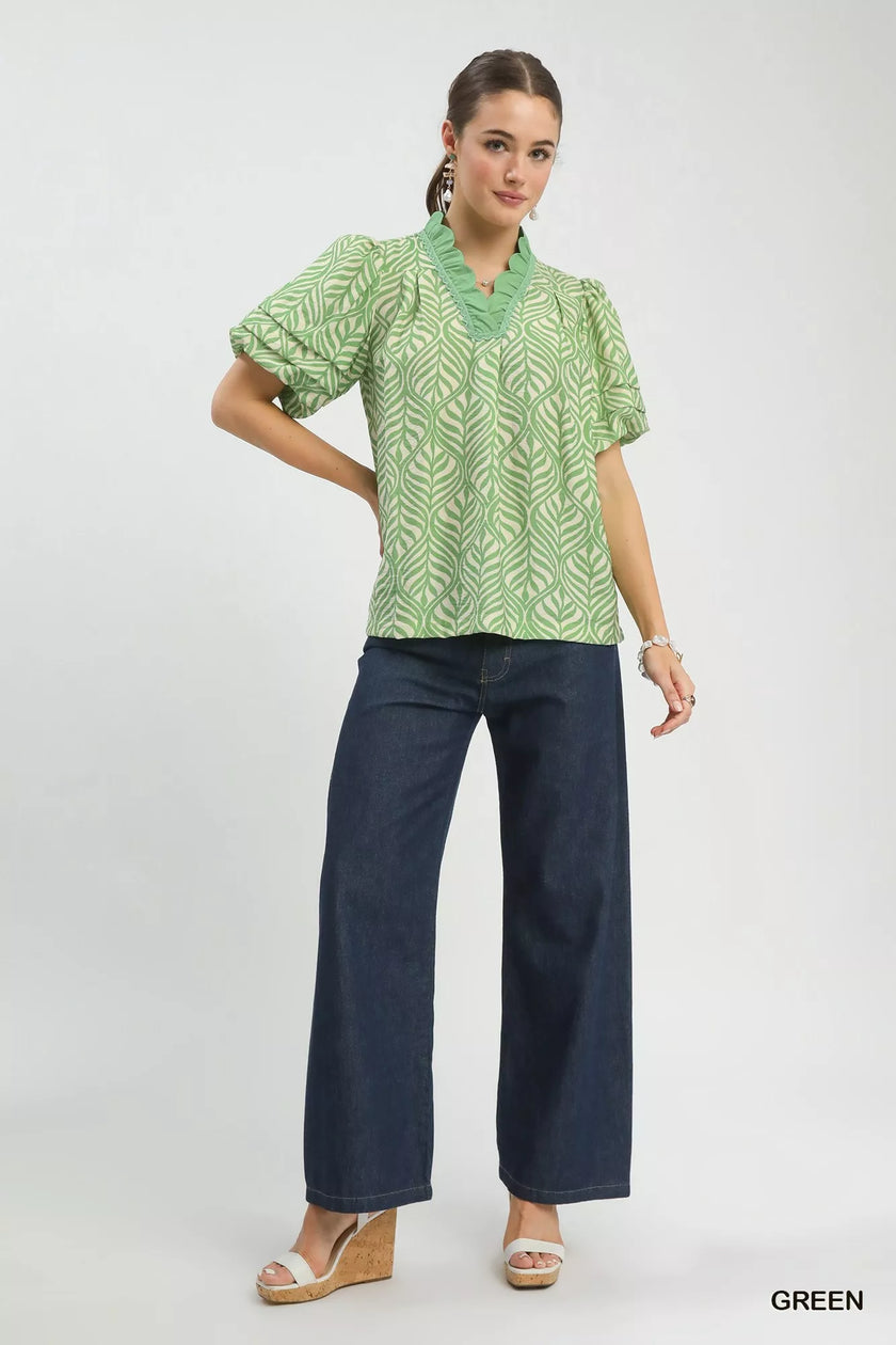 Leaf-patterned blouse with ruffle neck paired with wide-leg trousers