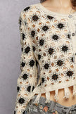 Cream and black openwork floral crochet cardigan with tassel hem and button closure