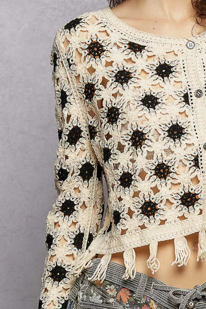 Cream and black openwork floral crochet cardigan with tassel hem and button closure