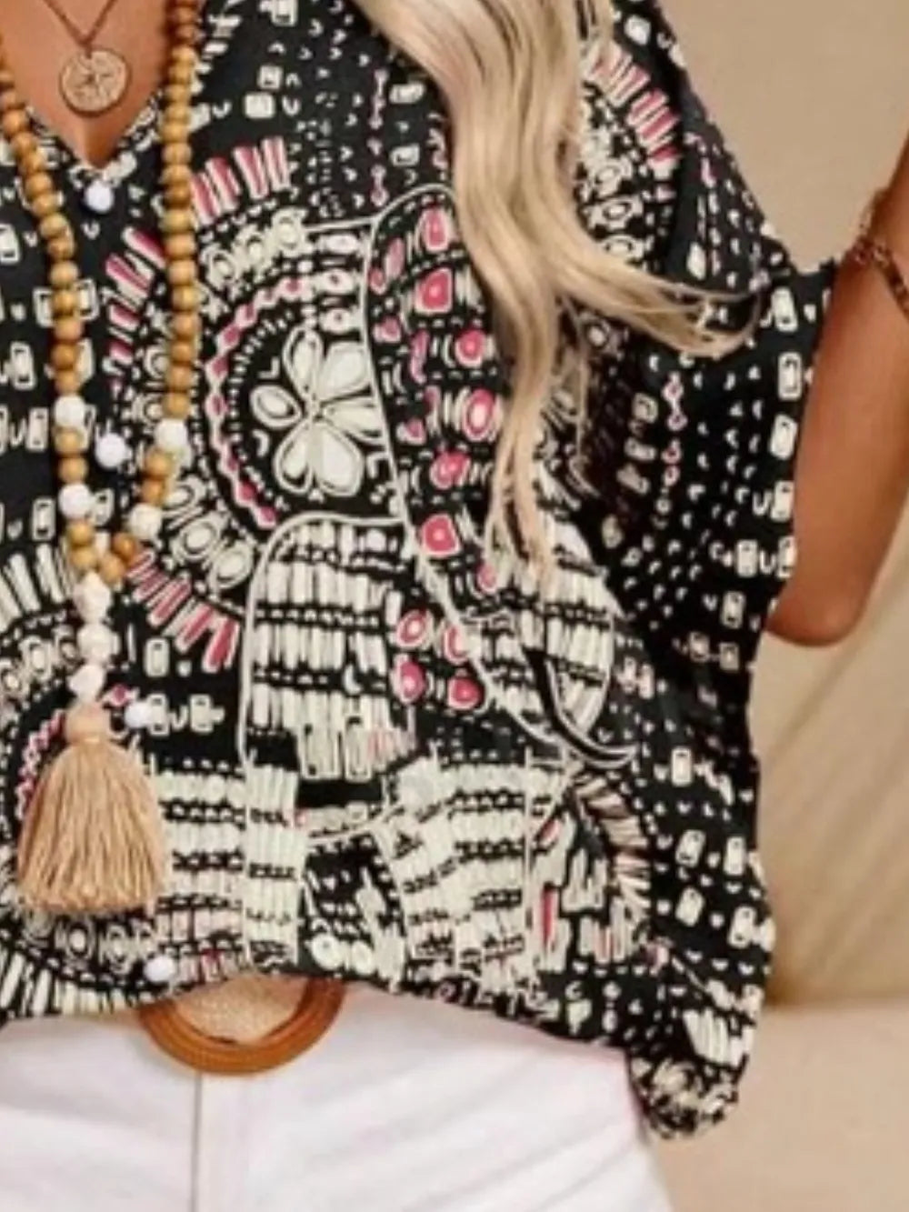 Black and white patterned V-neck top with pink accents, opaque polyester blend, loose fit