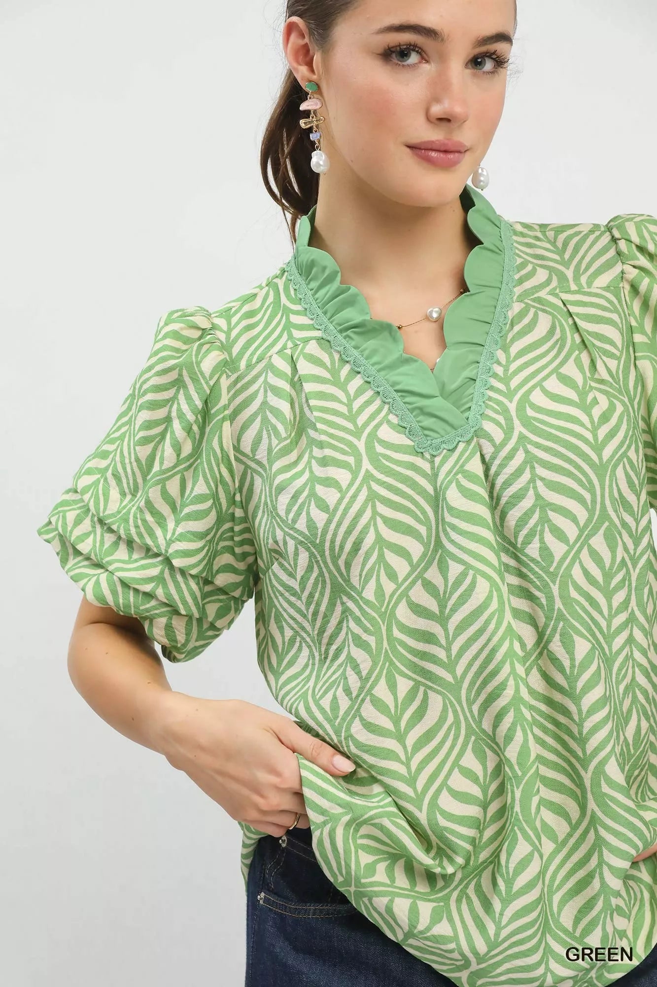 Green-and-white leaf print blouse featuring puff sleeves and ruffled neck